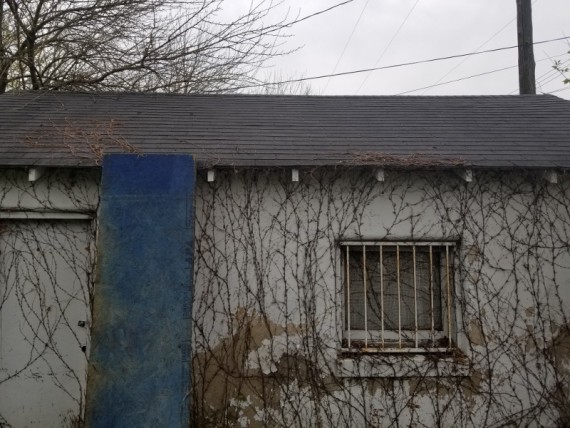 Detached concrete block one car garage.