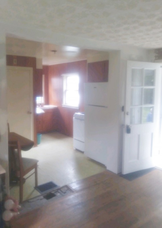 Cute one bed room cottage living room view into the kitchen.