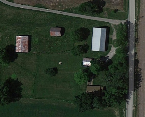 Up close aerial of house and outbuildings